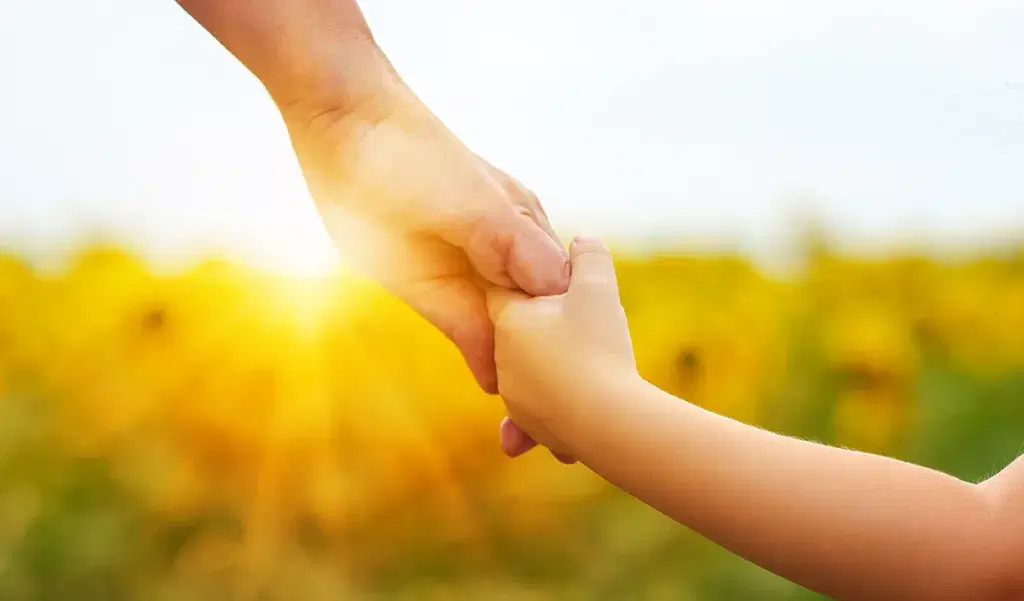 child and parent holding hands
