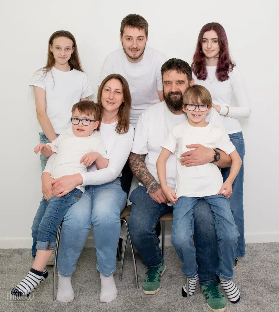 A family of 7 smiling at the camera